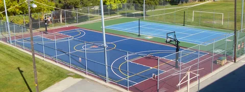 Modern sports facility with athletes training on indoor basketball court and weightlifting area